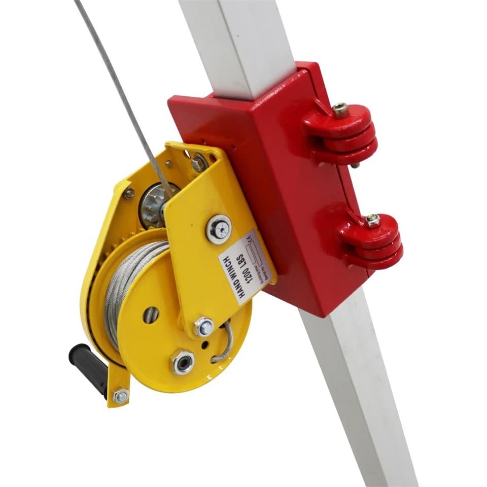 Close-up of the yellow hand winch and red mounting bracket on a tripod leg